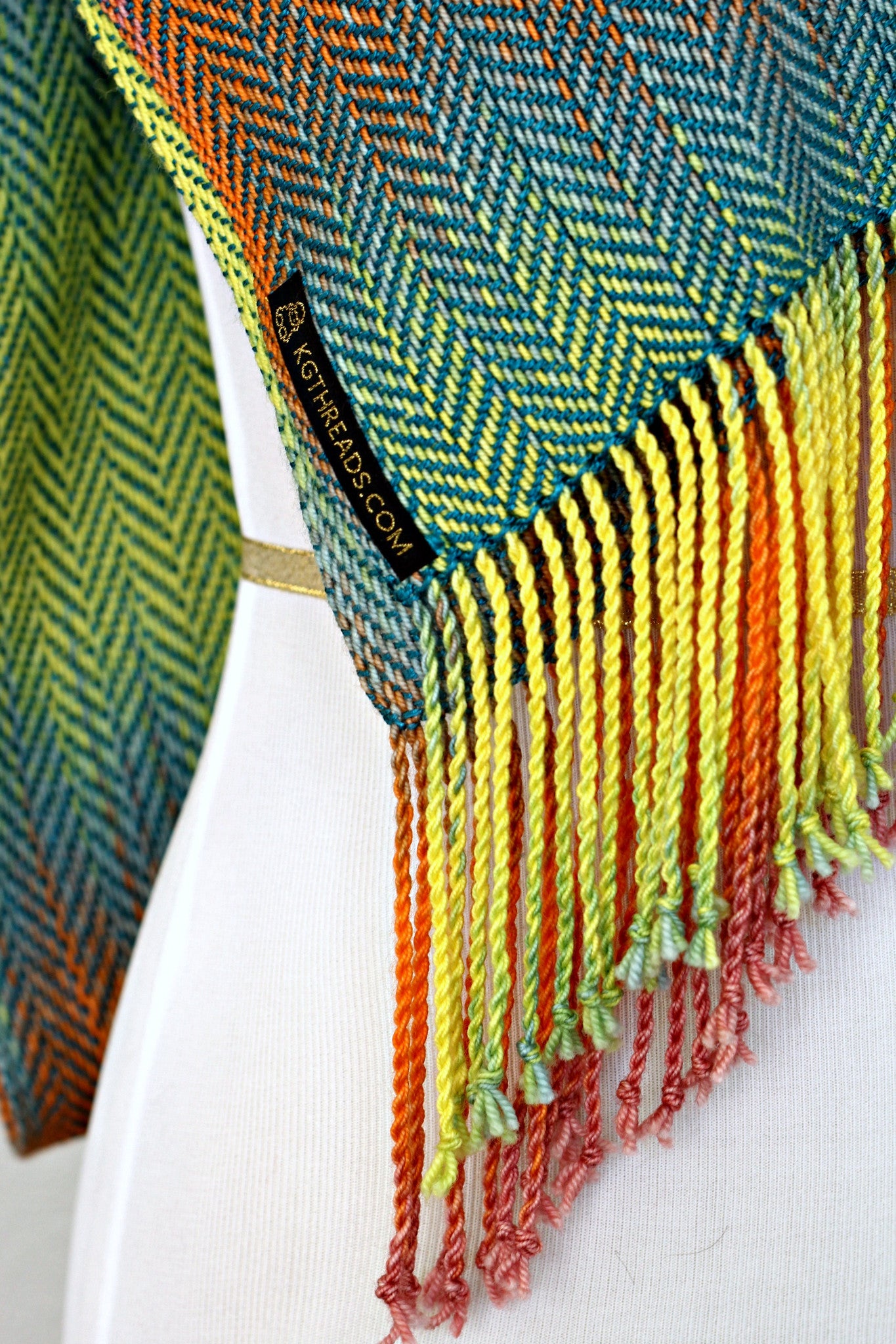 Woven scarf in blue, orange, purple and yellow colors with twill pattern and twisted fringe
