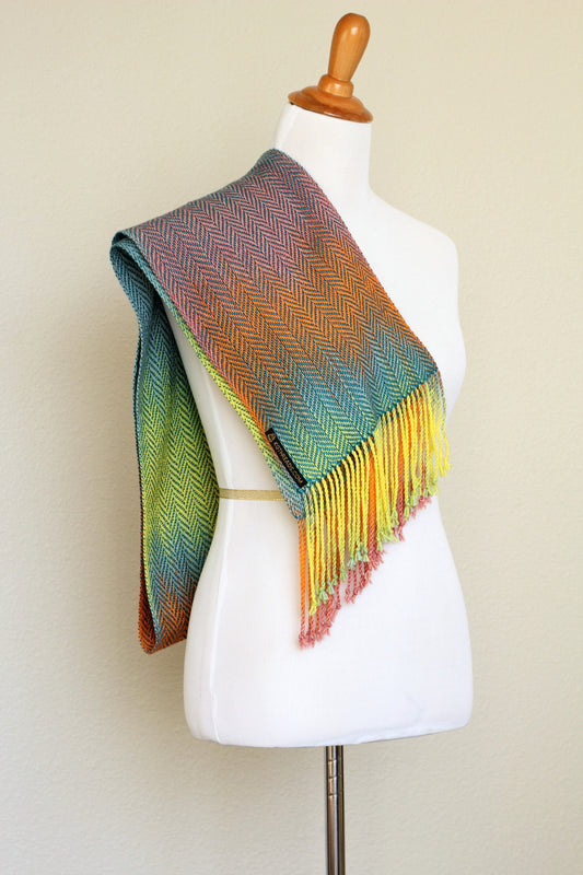 Woven scarf in blue, orange, purple and yellow colors with twill pattern and twisted fringe