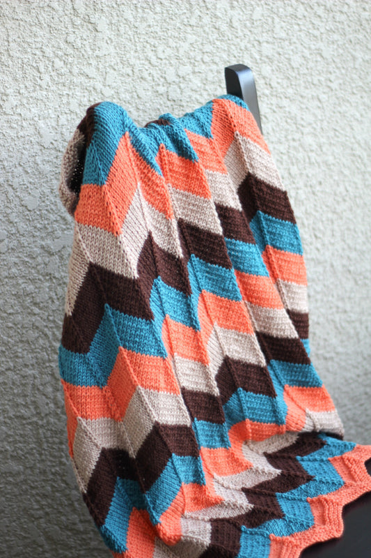 Knit baby blanket in orange and teal colors