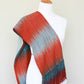 Woven scarf in blue grey, red and teal colors