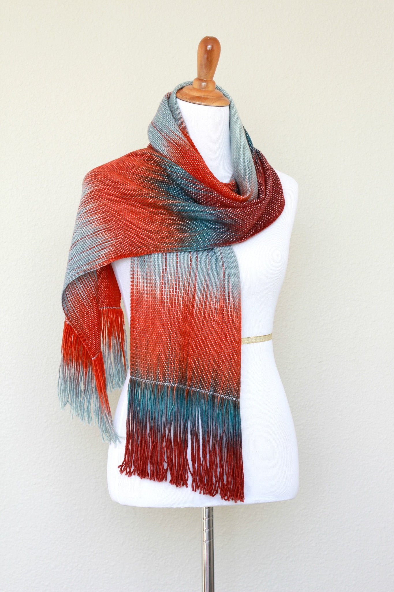 Woven scarf in blue grey, red and teal colors