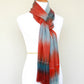 Woven scarf in blue grey, red and teal colors