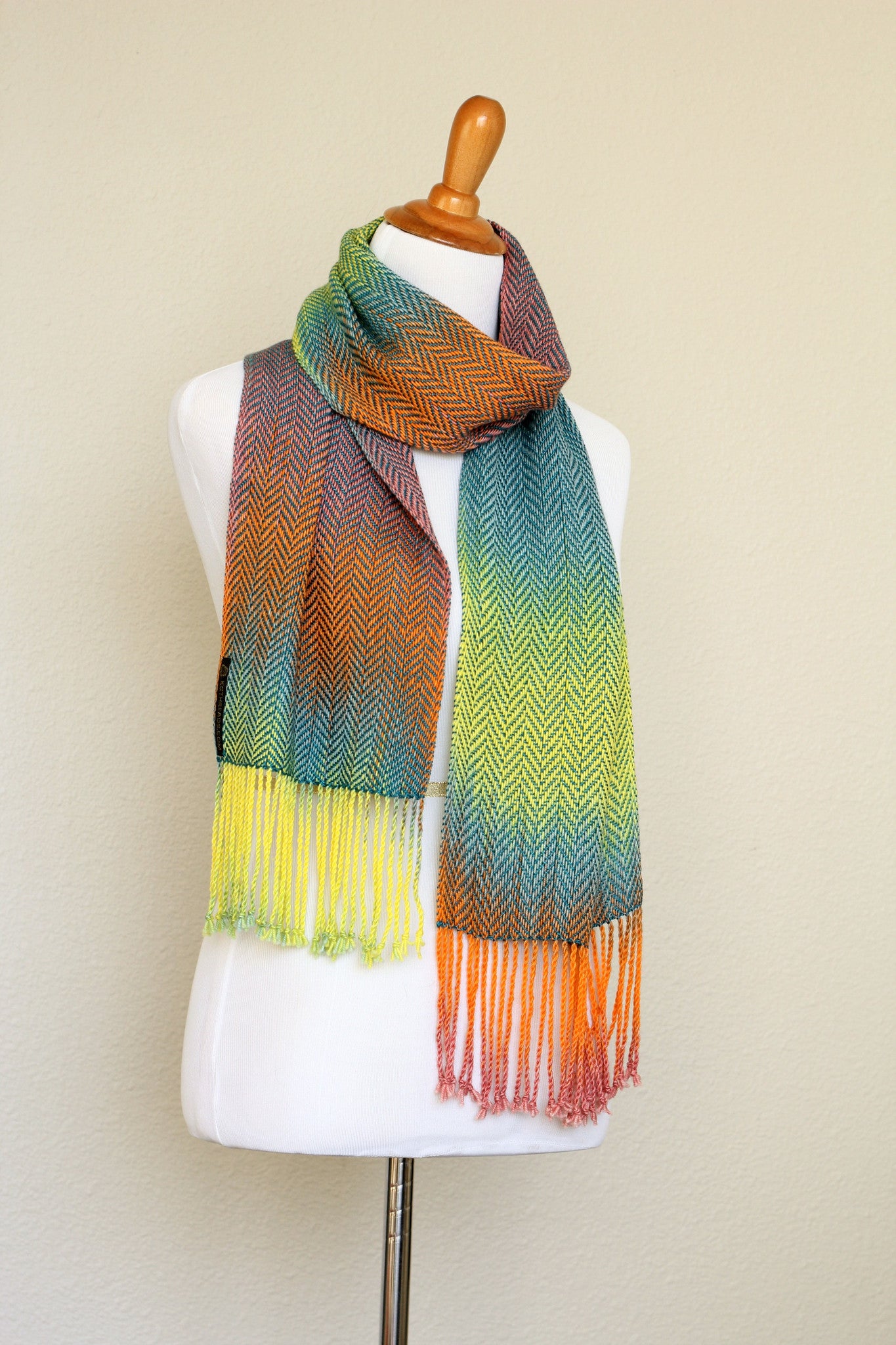 Woven scarf in blue, orange, purple and yellow colors with twill pattern and twisted fringe