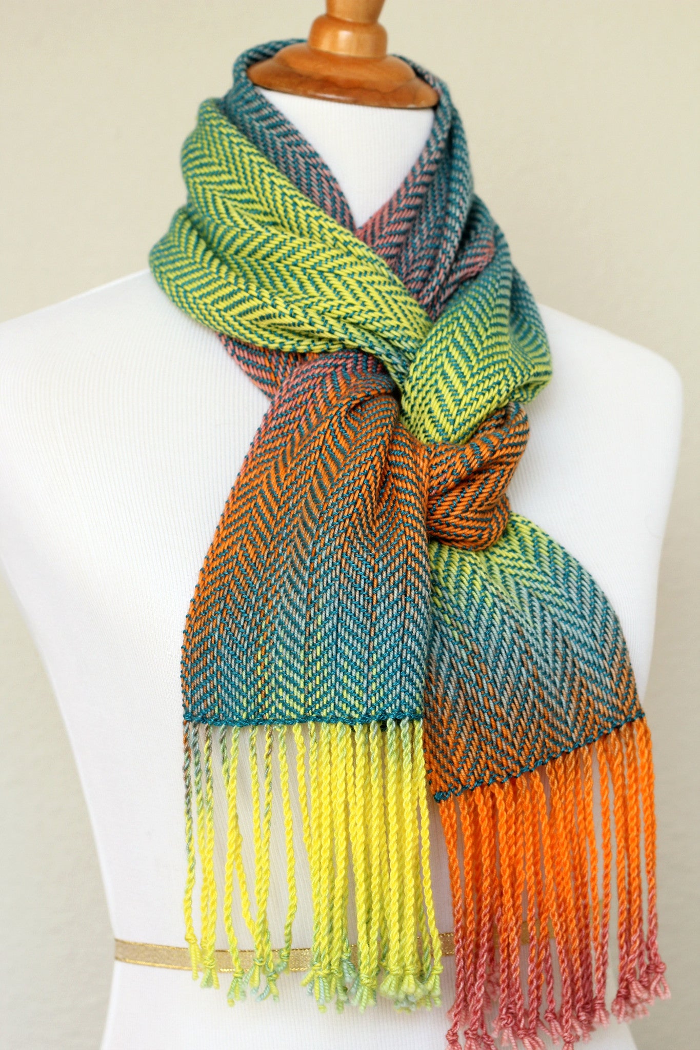 Woven scarf in blue, orange, purple and yellow colors with twill pattern and twisted fringe