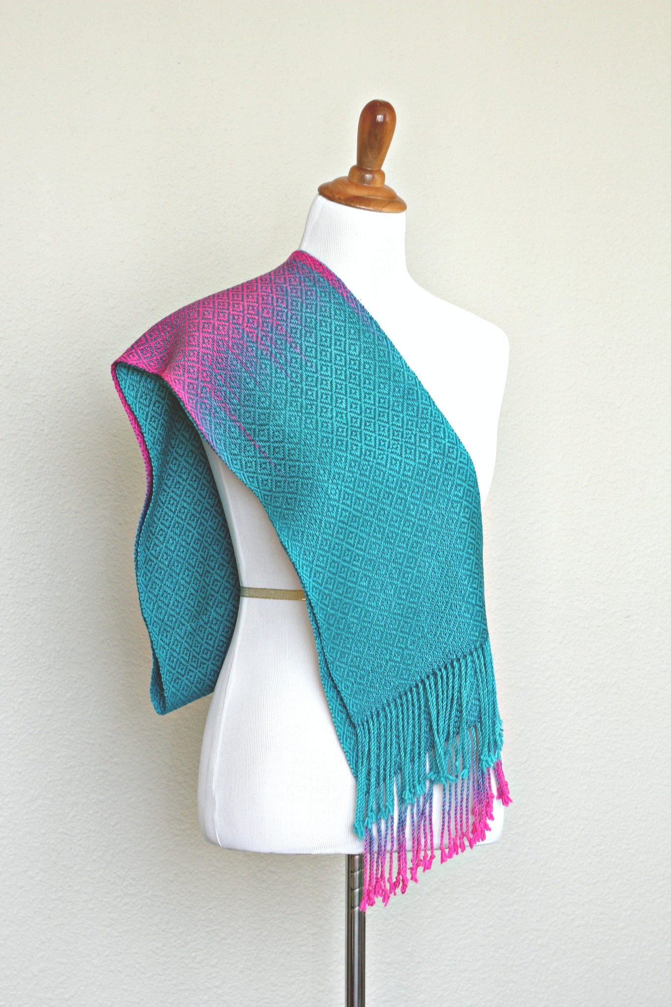 Woven scarf in blue and neon pink with woven pattern and twisted fringe