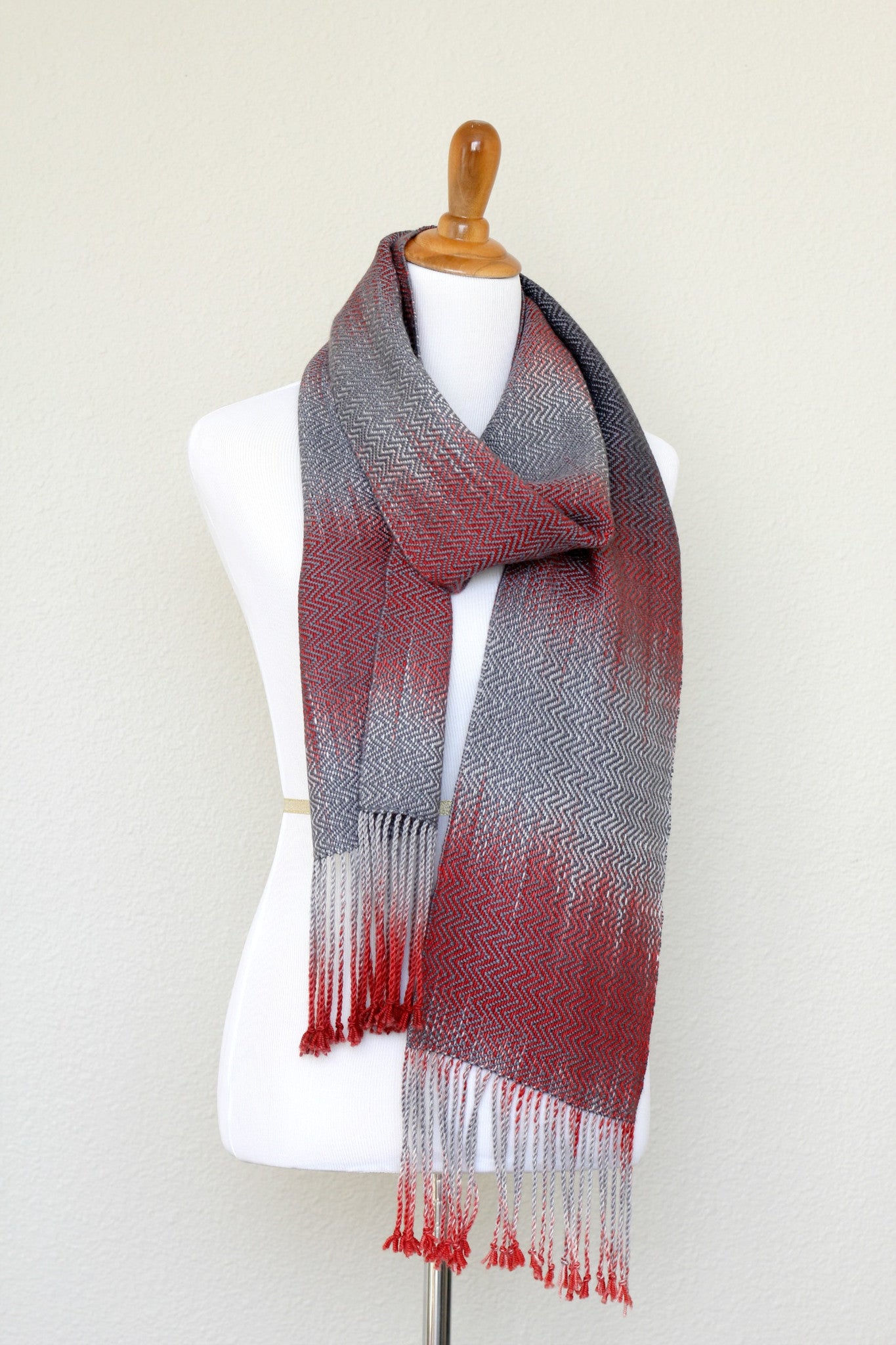 Woven scarf in red and grey colors with twill pattern and twisted fringe