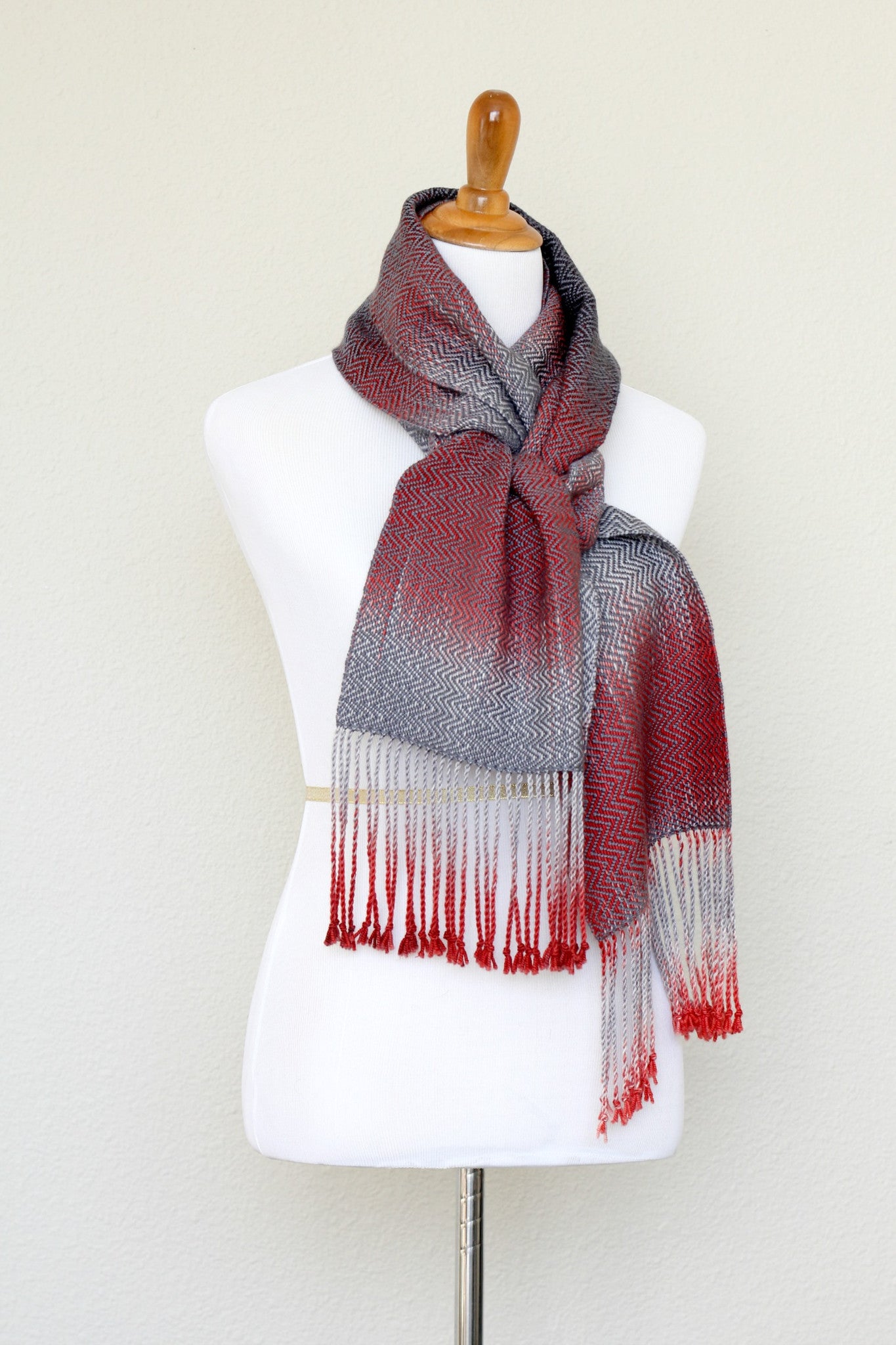 Woven scarf in red and grey colors with twill pattern and twisted fringe