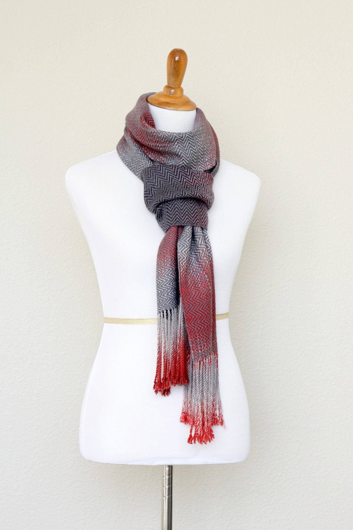 Woven scarf in red and grey colors with twill pattern and twisted fringe