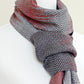 Woven scarf in red and grey colors with twill pattern and twisted fringe