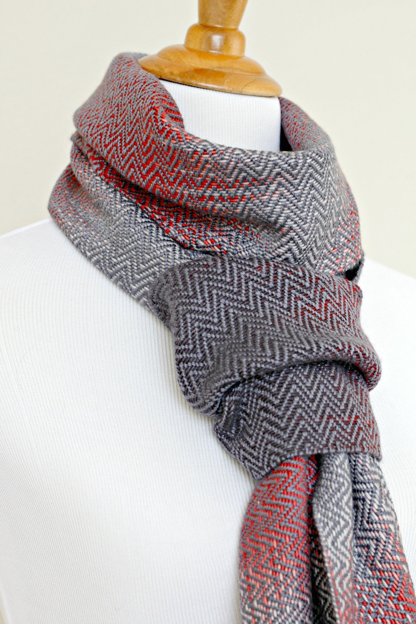 Woven scarf in red and grey colors with twill pattern and twisted fringe