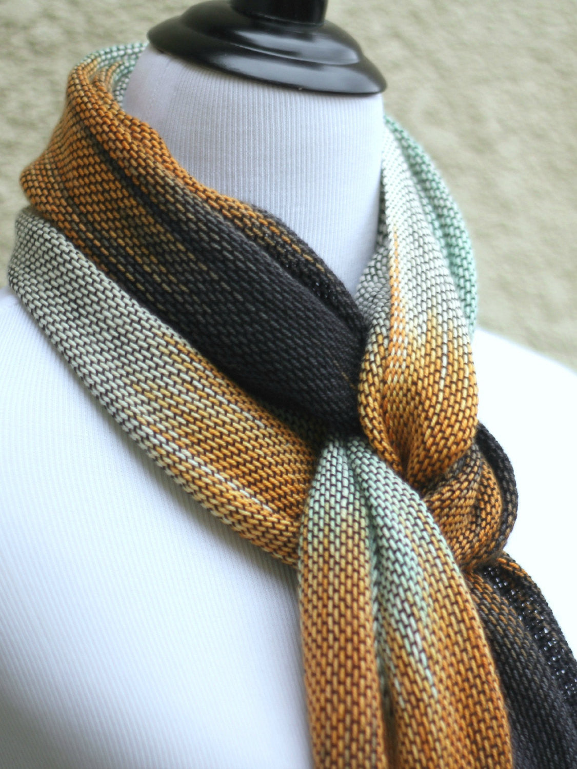 Hand woven scarf in white, orange, black and mint colors