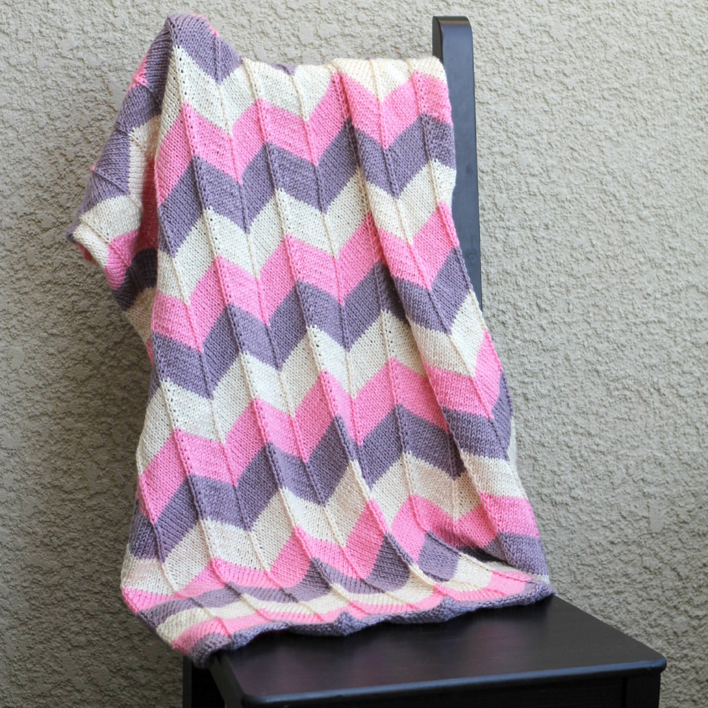 Pink knit baby blanket in chevron pattern