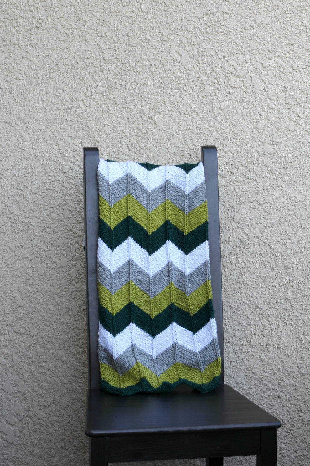 Knit baby blanket in green colors