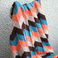 Knit baby blanket in orange and teal colors