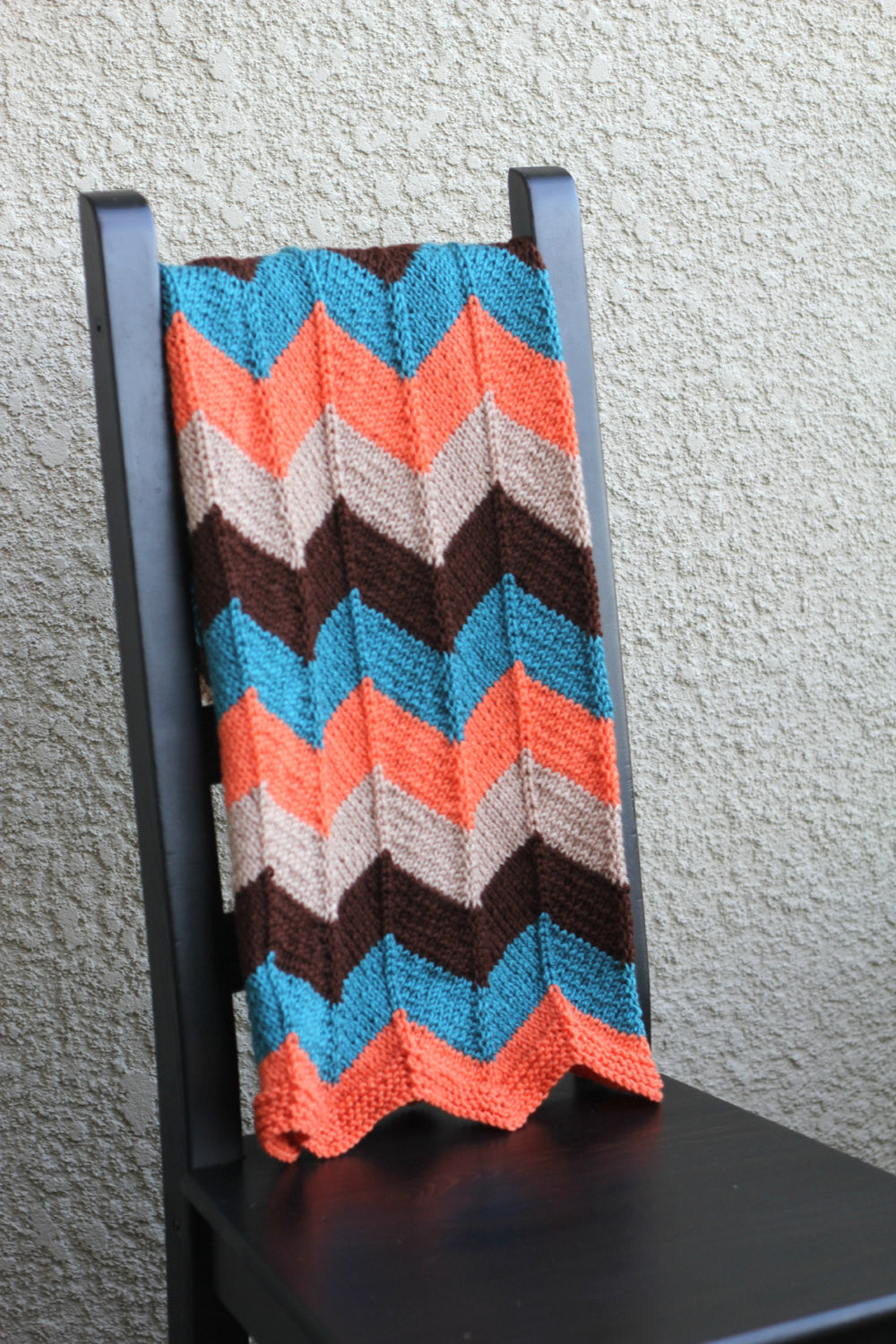 Knit baby blanket in brown and teal colors